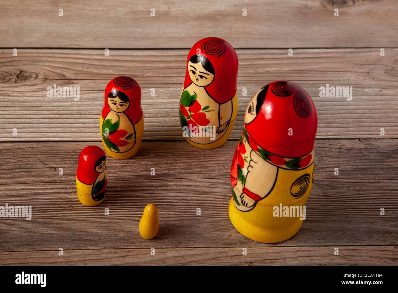 A close up isolated image of a set of handmade Russian Matrushka dolls that are lined up around a circle on wooden background. These folkloric women f Stock Photo