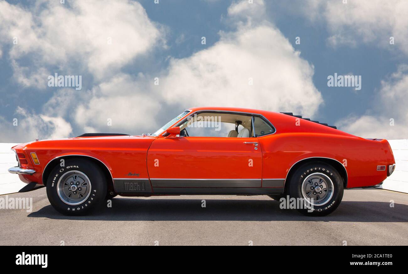 Profile of a 1970 Ford Mustang Mach 1 in bright orange, a legendary American muscle car. Stock Photo