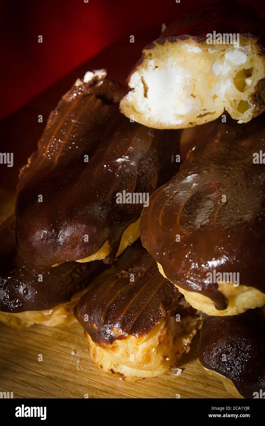 Eclairs with chocolate icing on a wooden table Stock Photo