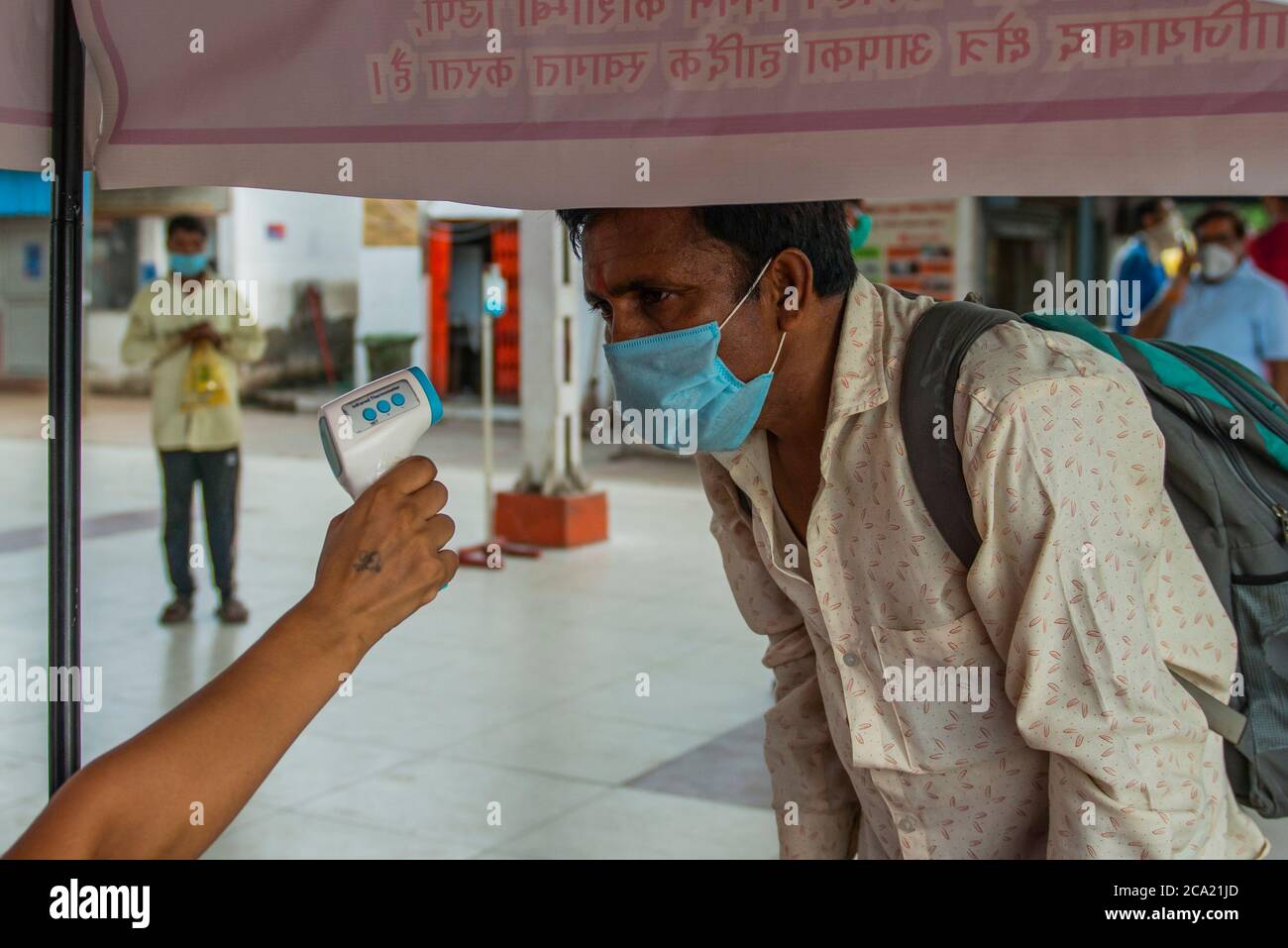 New Delhi, India. 03rd Aug, 2020. A man wearing a face mask as a preventive measure gets her body temperature checked at the bus depot.Uttar Pradesh Government offers free ride for all women travelling today for Rakshabandhan (Rakhi), while travelling amid Covid-19 period the government arranged thermal screening and hand sanitizer at the Bus Depot as well as inside the buses. Credit: SOPA Images Limited/Alamy Live News Stock Photo
