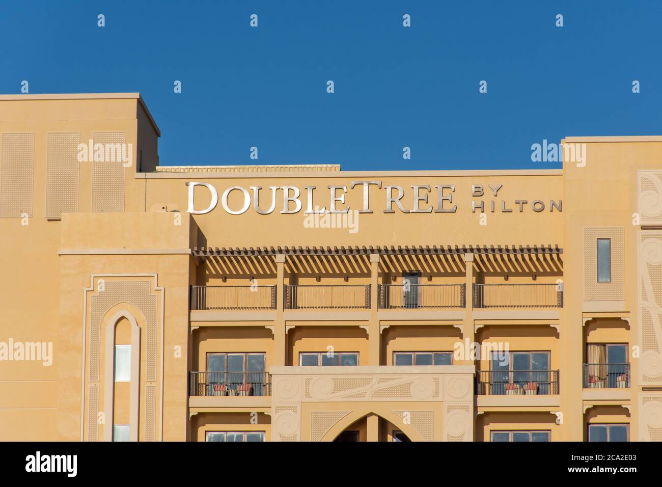 'Ras al Khaimah, Ras al Khaimah/United Arab Emirates - 2/14/2020: 'Hilton Double Tree Hotel close up of building sign against blue sky background Marj Stock Photo