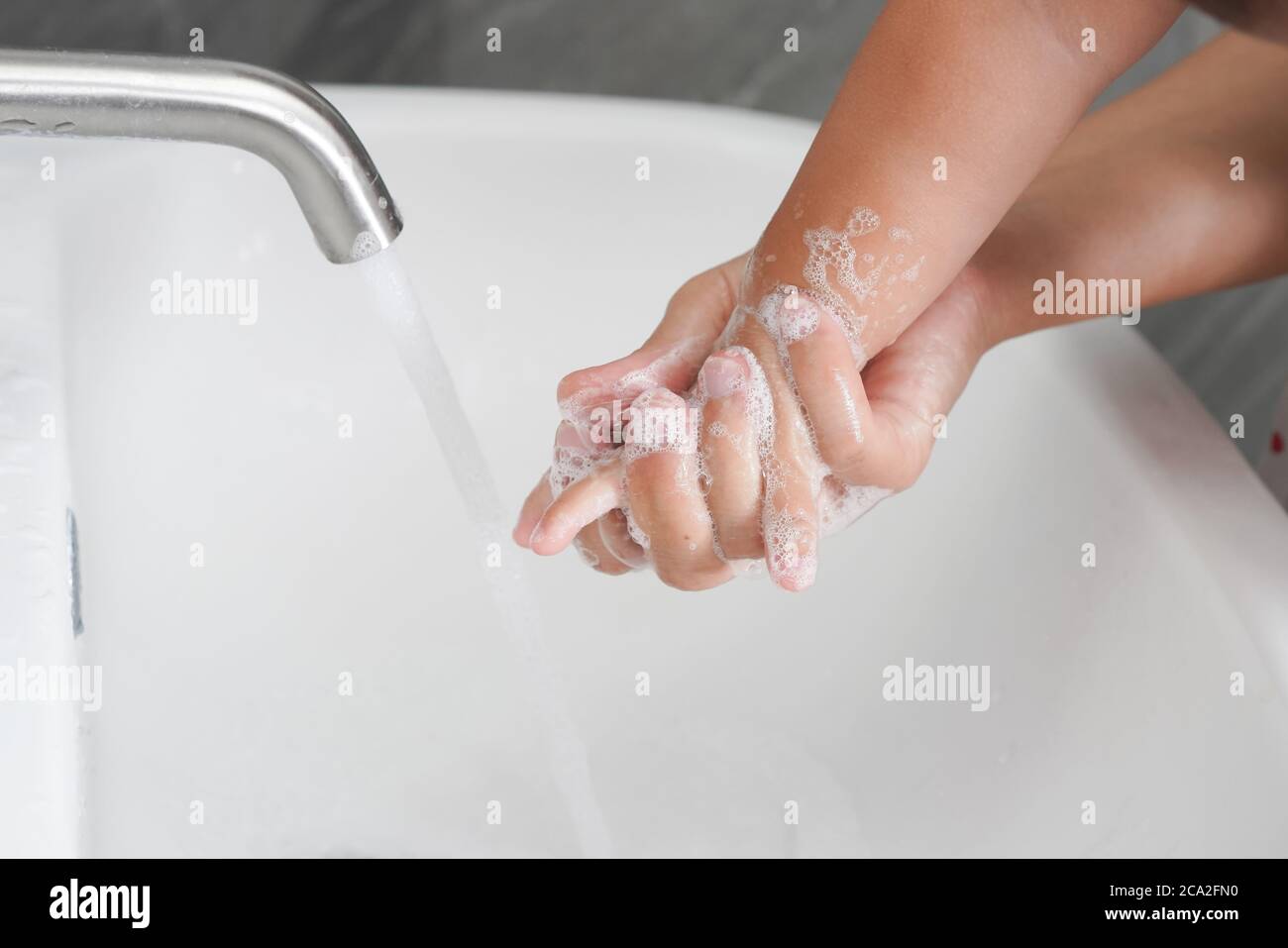 Mother wash baby hand prevention of novel Coronavirus Disease 2019 or COVID-19 . Stock Photo