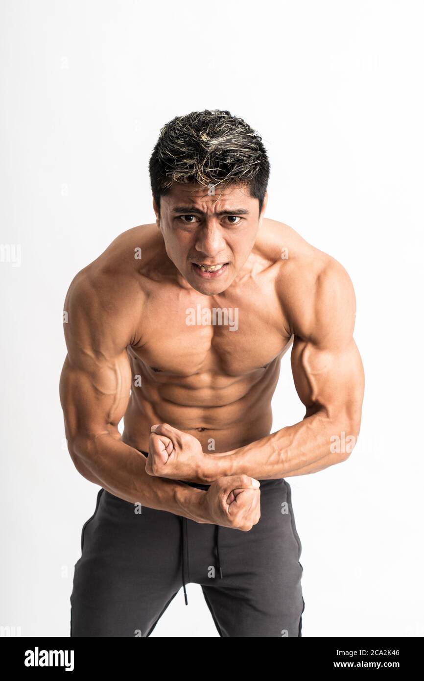 asian young man showing a muscular body stand facing forward look the camera  on isolated background Stock Photo - Alamy