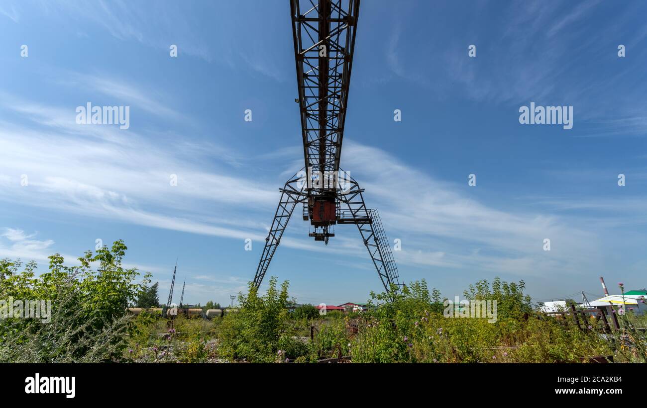 Large metal gantry cranes at a construction site against the blue sky. Type of bearing metal
