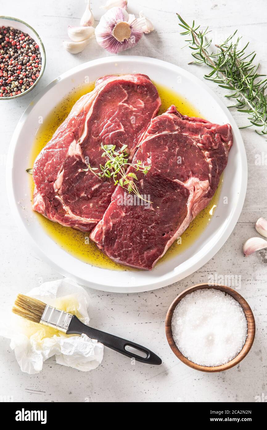 Two Rib eye steak salt spices rosemary garlic in olive oil top of
