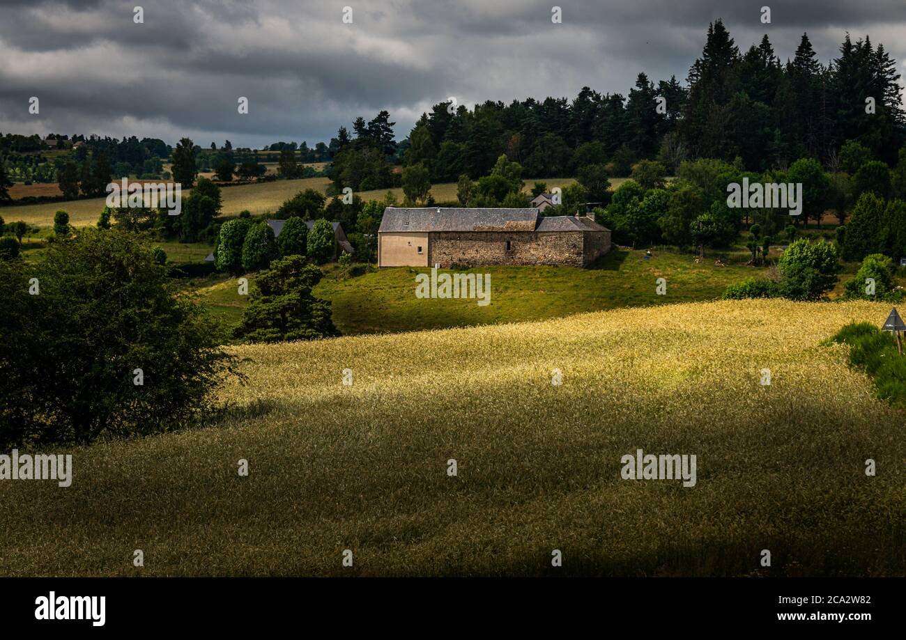 Rustic stone farmhouse in a rolling landscape with cloudy skys, Lozere , France. Stock Photo
