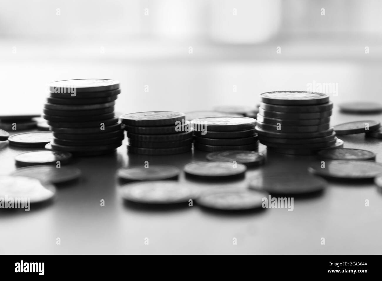 Euro and Europe Coins stacks,diferent sizes and colors.Saving money concept,business and banking..Blurred background.Black and white image. Stock Photo