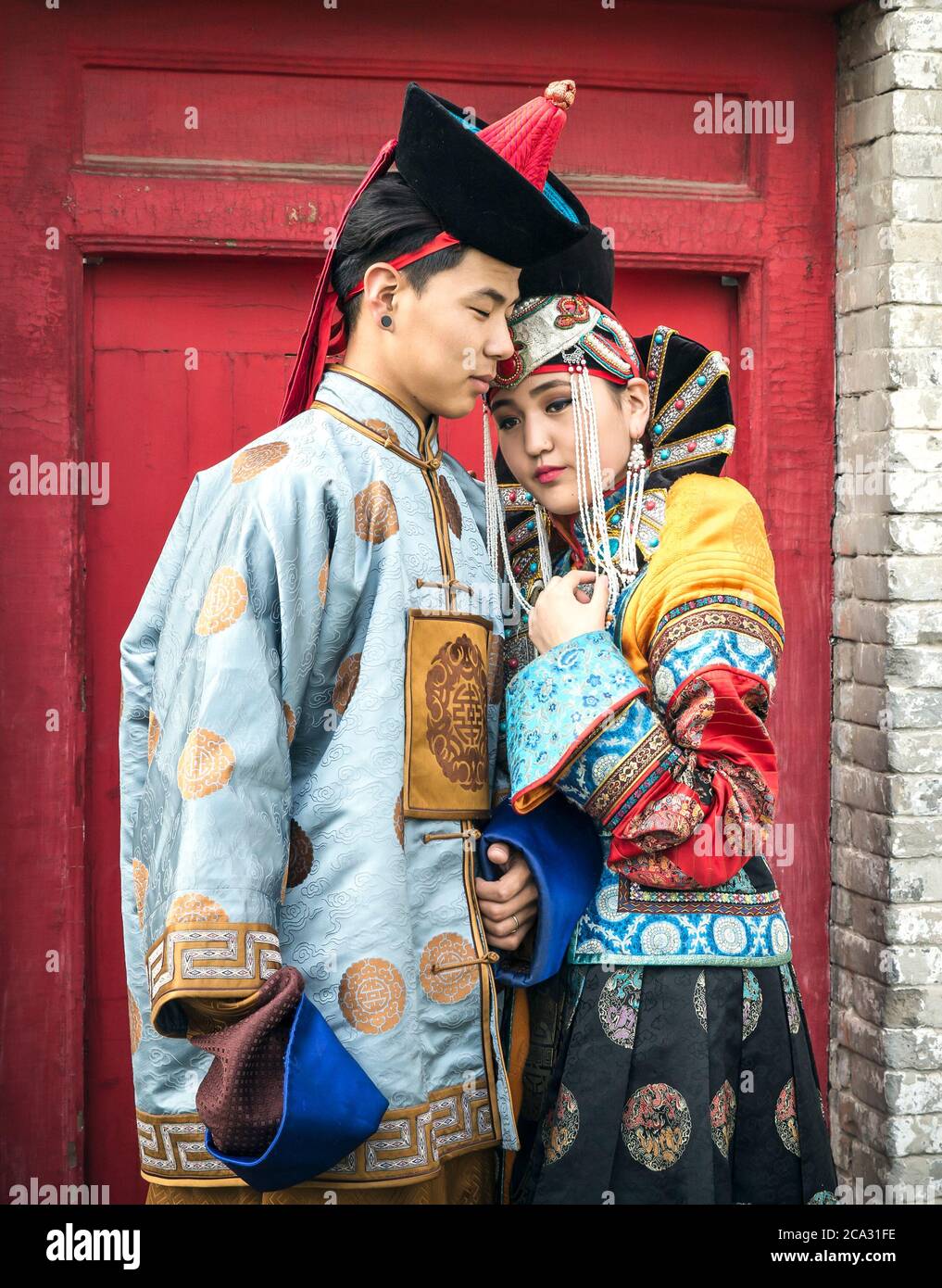 young Mongolian couple in traditional 13th century clothing in a temple gardens in Ulaanbaatar Stock Photo