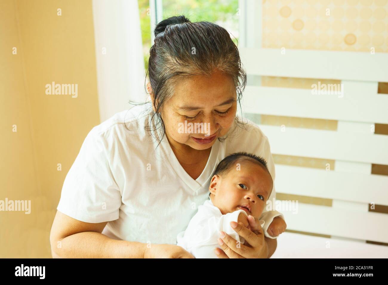 Asian grandmother is playing with her grandchild. Stock Photo