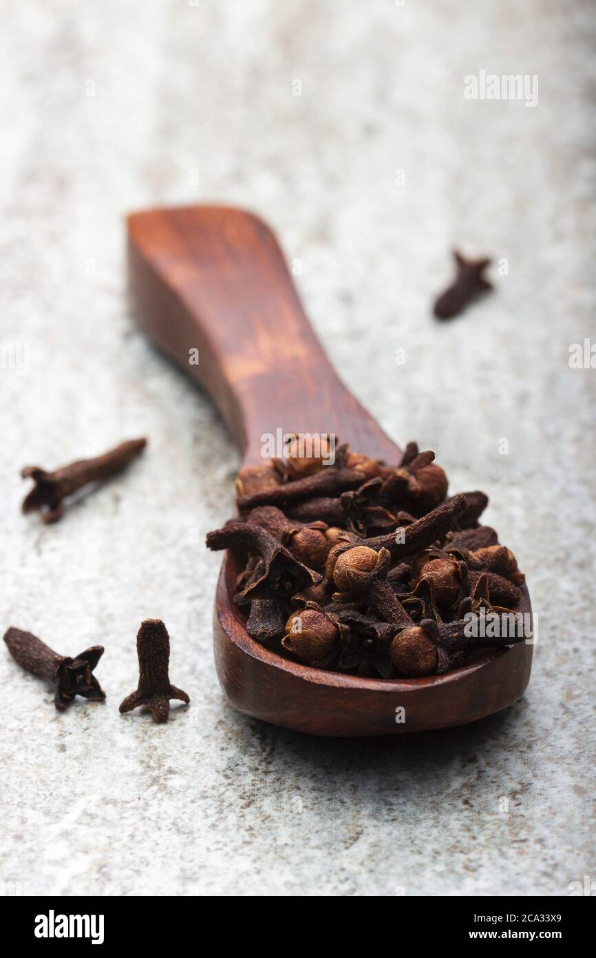 Macro closeup image of dried cloves in wooden spoon. Used as spices and aroma. Stock Photo