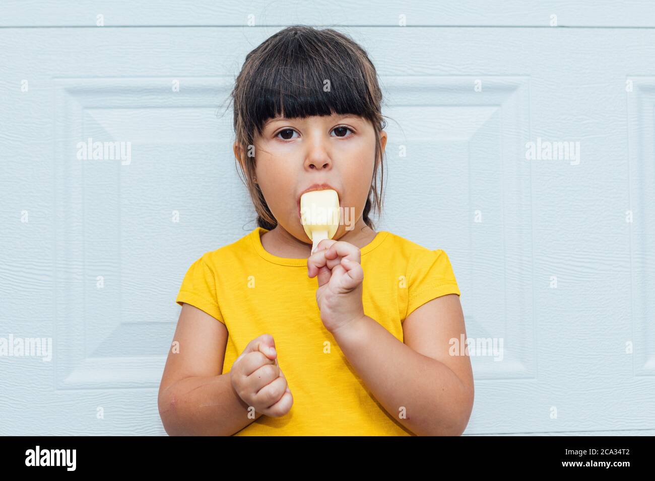 A Boy Wearing A White Shirt Is Eating Ice Cream Stock Photo