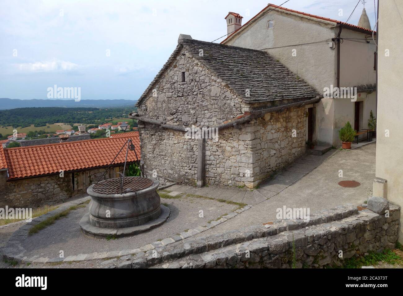 Medieval village house with stone raiwater rooftop catchment sistem and stone reservoar. Štanjel village, Komen municipality, Kras region, Slovenija. Stock Photo