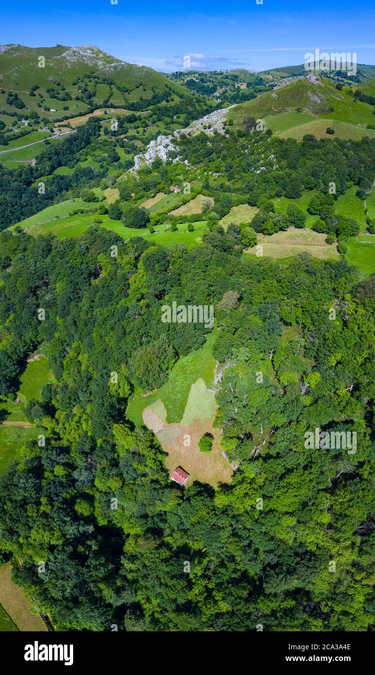 Spring landscape of mountains, meadows of mowing and cabins pasiegas in the Miera Valley, Cantabria, Spain, Europe. Stock Photo