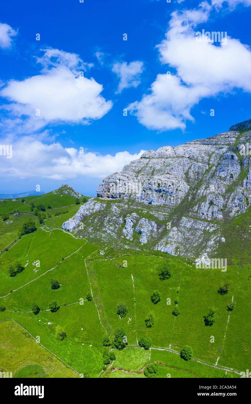 Spring landscape of mountains, meadows of mowing and cabins pasiegas in the Miera Valley, Cantabria, Spain, Europe. Stock Photo