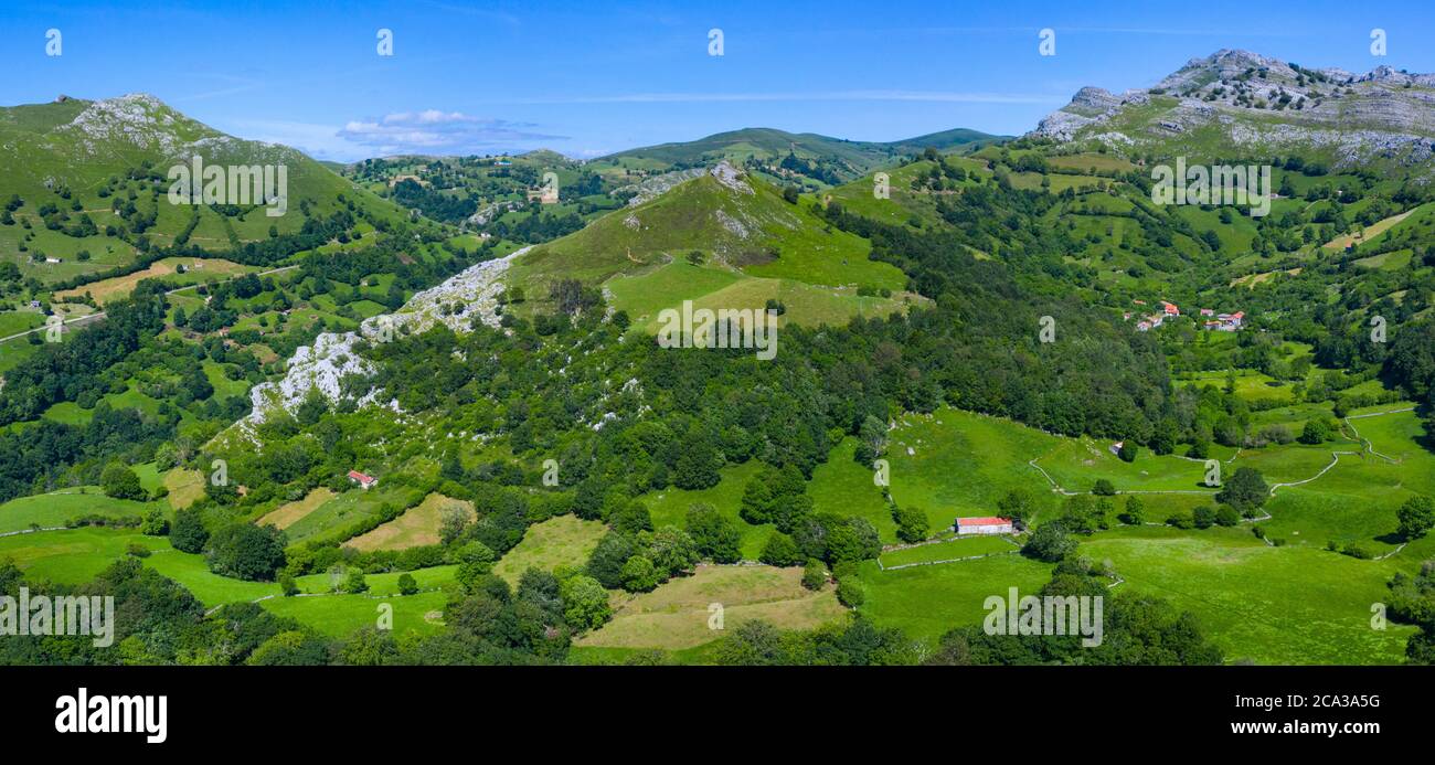 Spring landscape of mountains, meadows of mowing and cabins pasiegas in the Miera Valley, Cantabria, Spain, Europe. Stock Photo