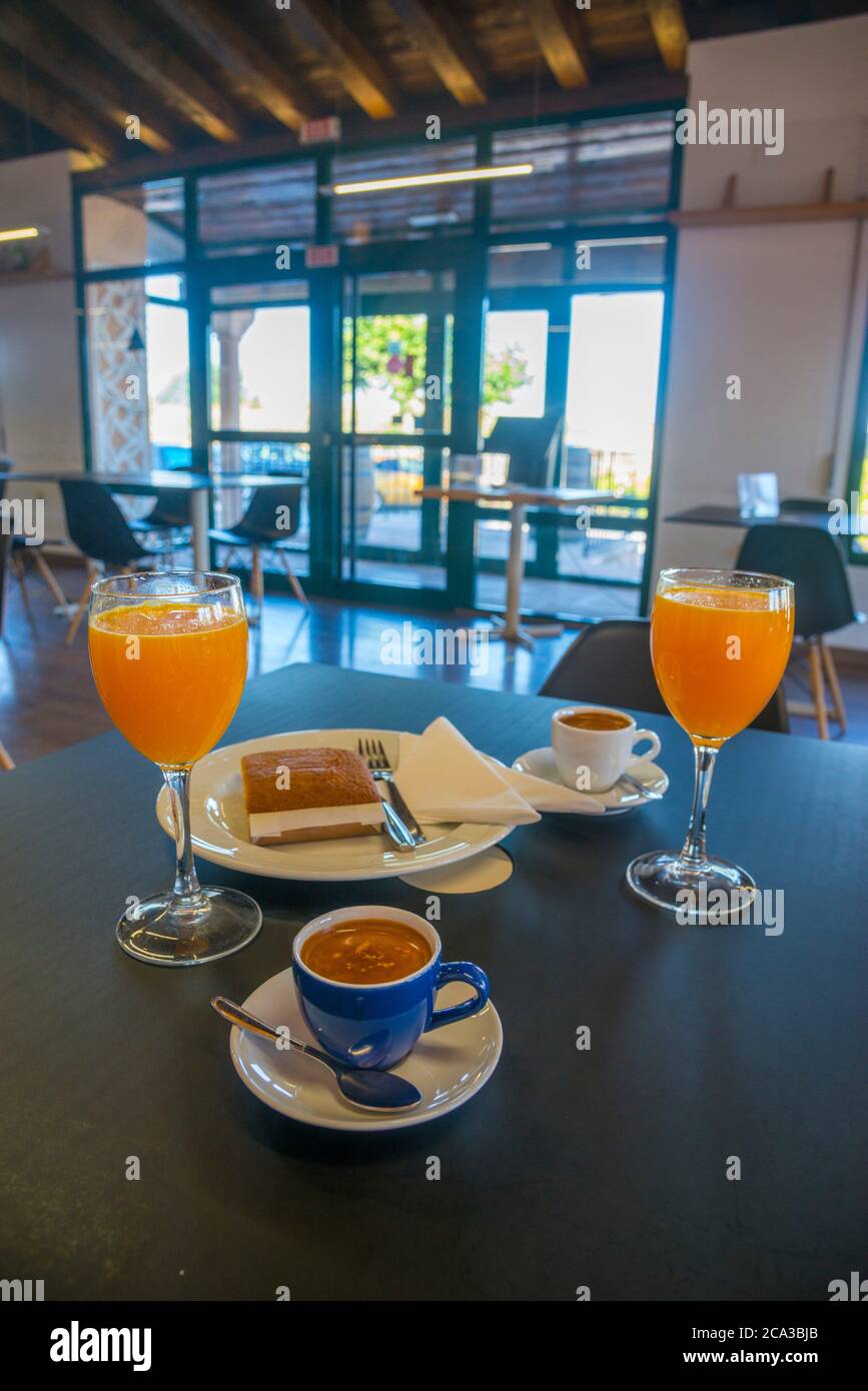 Orange juice, cups of coffee and sobao pasiego in a cafeteria. Spain
