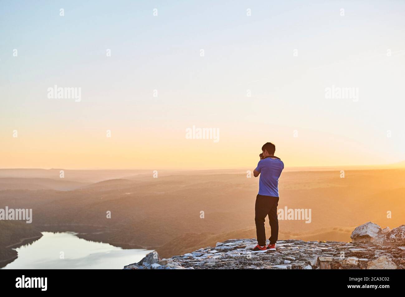 Young man taking pictures to sunset in Monfragüe National Park, Extremadura (Spain) Stock Photo