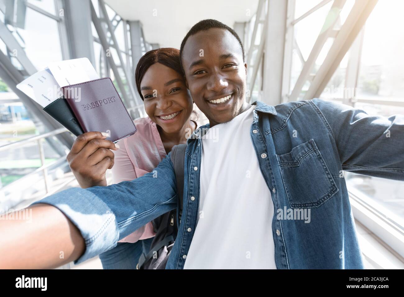 Excited Black Couple Making Selfie In Airport While Waiting For Thier Flight Stock Photo