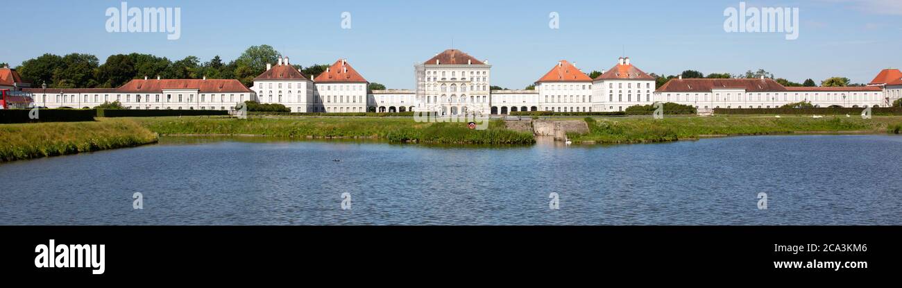 Large panorama of Nymphenburg Palace. Clear blue sky, with water in the foreground. No people. Stock Photo