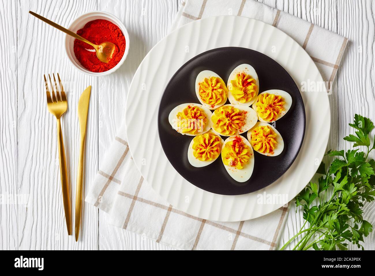 Festive appetizer: devilled eggs with a mix of egg yolks, sriracha sauce, mayonnaise, apple cider vinegar sprinkled with smoked paprika on a plate on Stock Photo