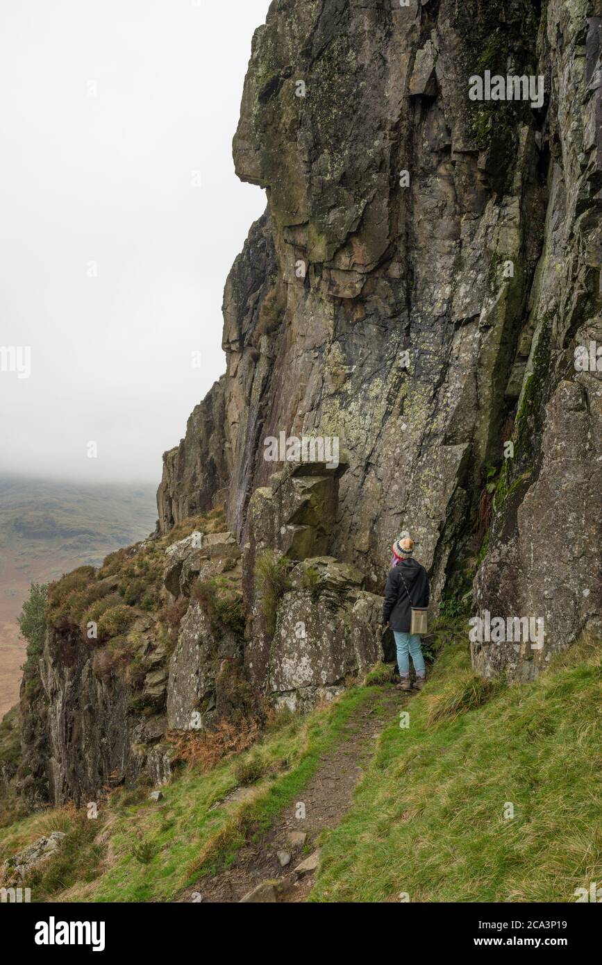 A young woman at Fat Man’s Agony on Side Pike in the Lake District National Park, Cumbria, England. Stock Photo