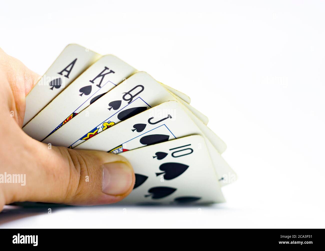 a gambler reveals a royal flush in spades. Gambling and luck. Decisions and risks. Isolated on a white background Stock Photo