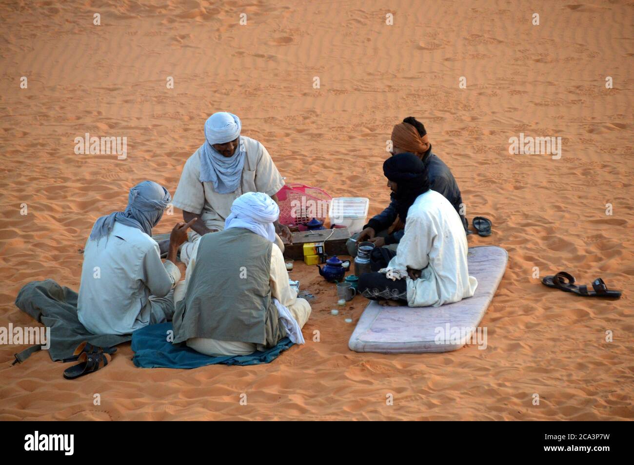 Algeria, Illizi, Tassili N'Ajjer National Park: group of Tuareg relaxing in the sand dunes at Tin Merzouga. Stock Photo