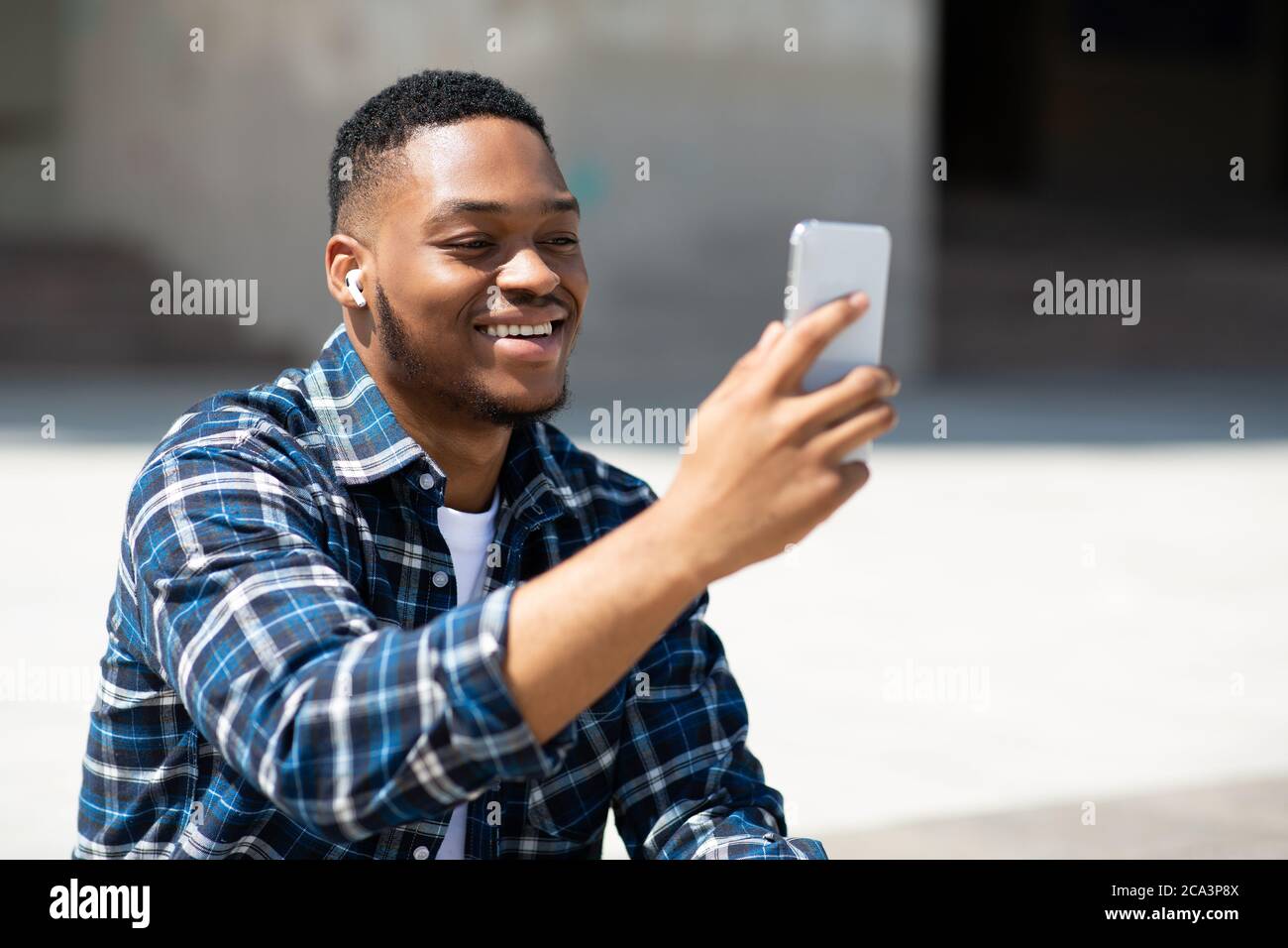 Portrait of black guy watching video on cell phone Stock Photo