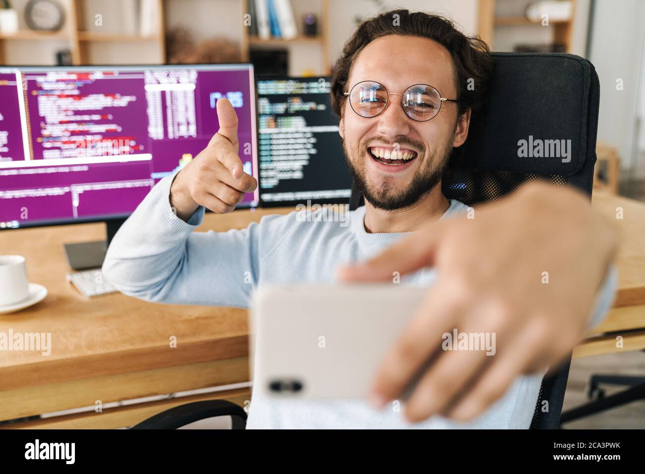 Image of unshaven joyful programmer man taking selfie photo and ...