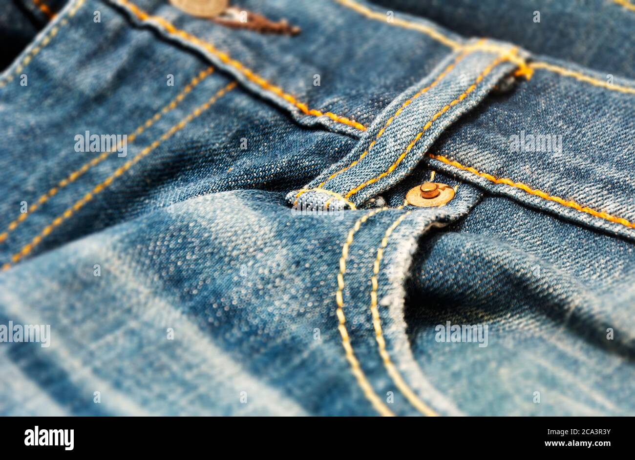 close-up view of the copper rivet on the pocket of a pair of denim trousers. Casual and workwear. Denim fabric for jeans trousers Stock Photo