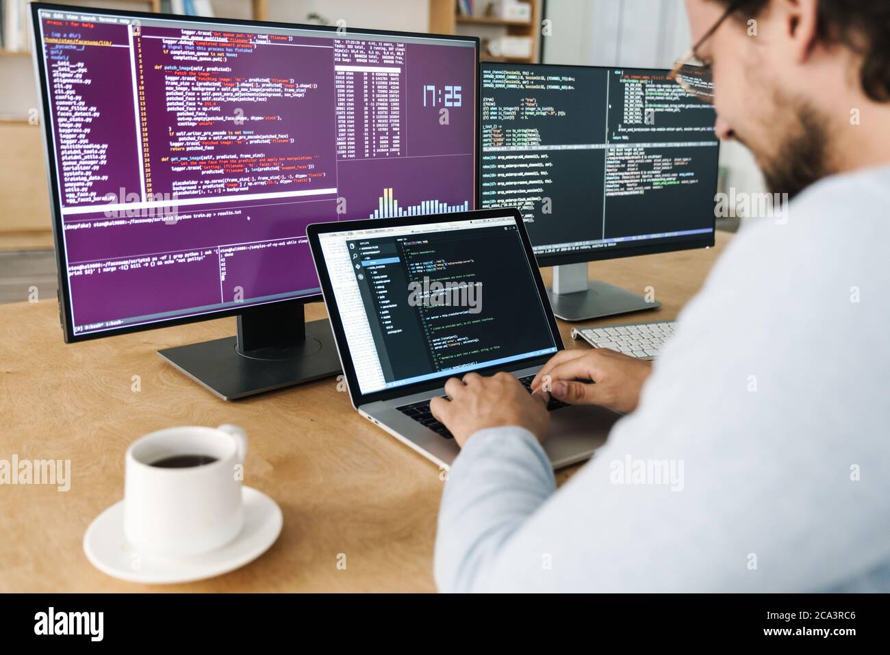 Cropped image of programmer man typing on keyboard while working with computers in office Stock Photo