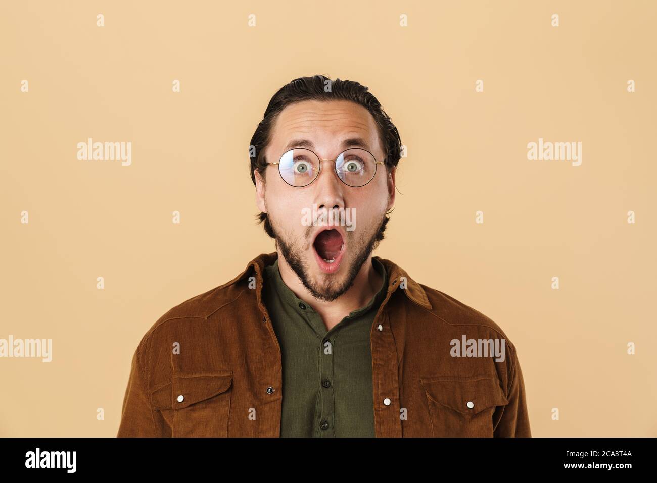 Image of handsome shocked man in eyeglasses expressing surprise at