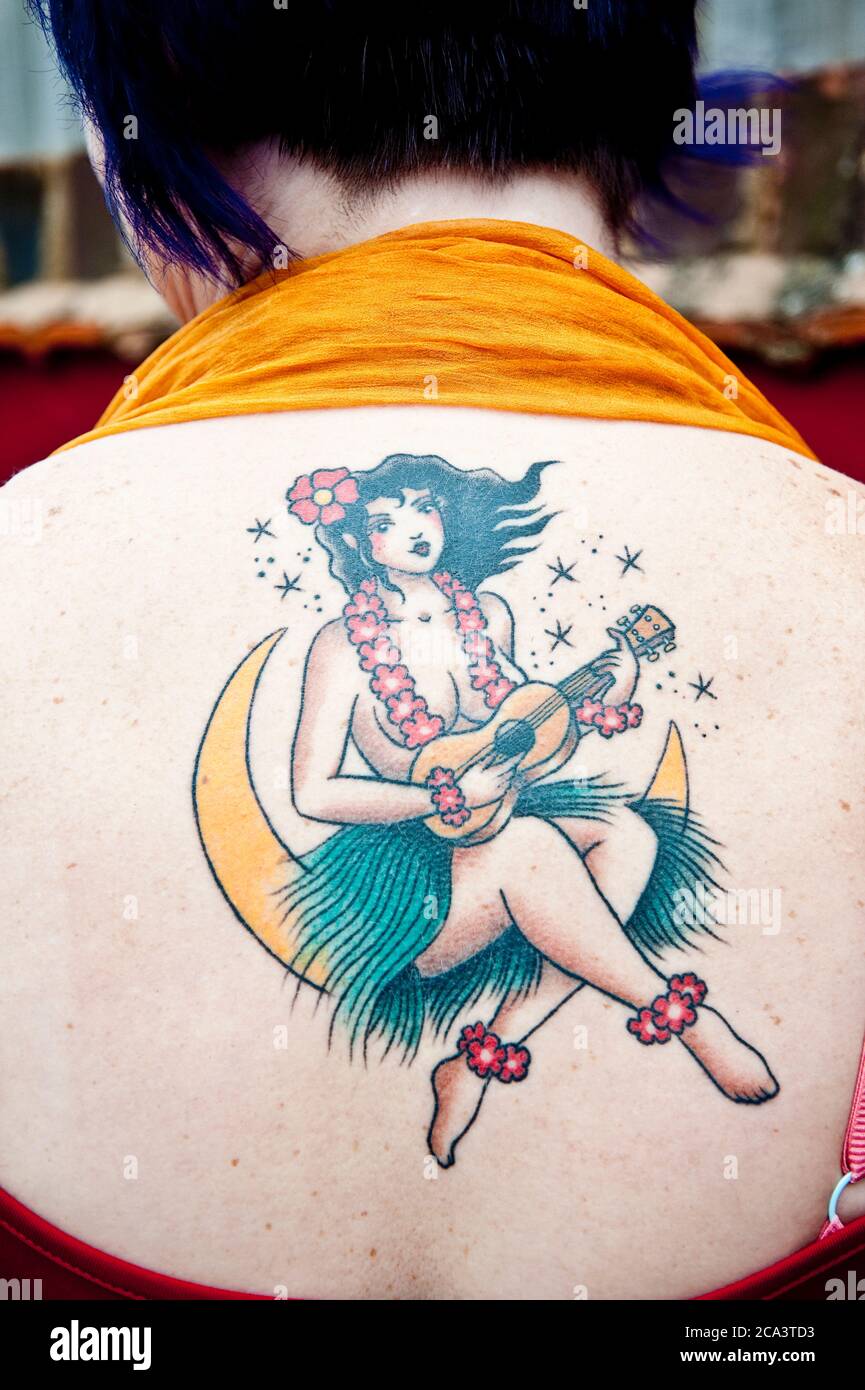 Tattoo of a girl playing ukulele Stock Photo