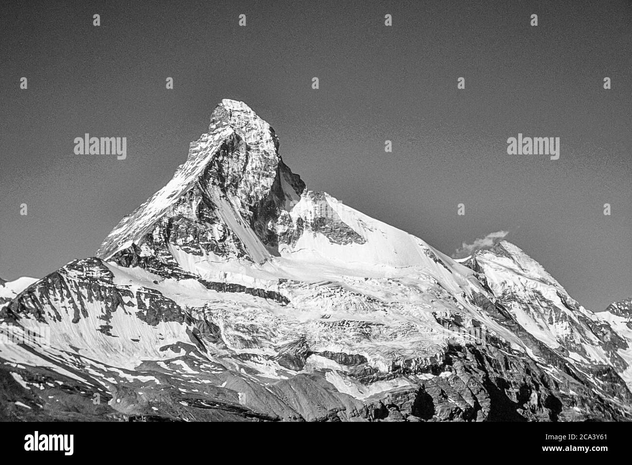 Switzerland. Zermatt. This is the famous Matterhorn mountain with the prominent Hoernli Ridge, to the near left, the route followed during the first and tragic ascent on 15 July 1865. The skyline ridge to the right is the Zmuttgrat. The mountain on the far right is the Dent d'Herens. The iconic Matterhorn is the heart and soul of the Swiss mountain holiday resort town of Zermatt in the Swiss Canton of Valais Stock Photo