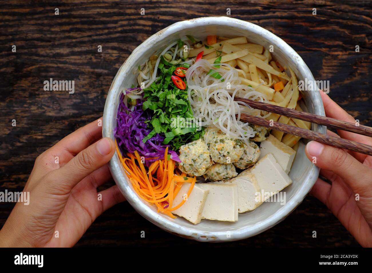 Homemade Vietnamese vegan noodles soup with vegetables as carrot, violet cabbage,tofu sliced, balls,delicious, nutrition, healthy vegetarian dish bowl Stock Photo