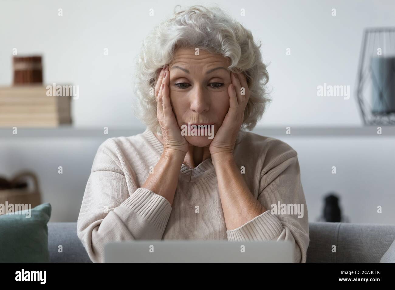Grandmother grab her head felt shock what saw on internet Stock Photo