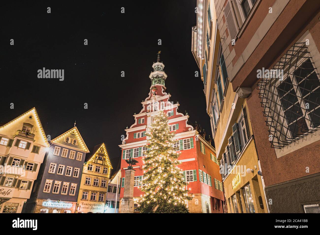 A Christmas tree stands by the Esslingen Altes Rathaus (Old Town Hall) during a clear night in the German medieval Rathausplatz (City Hall Square) Stock Photo