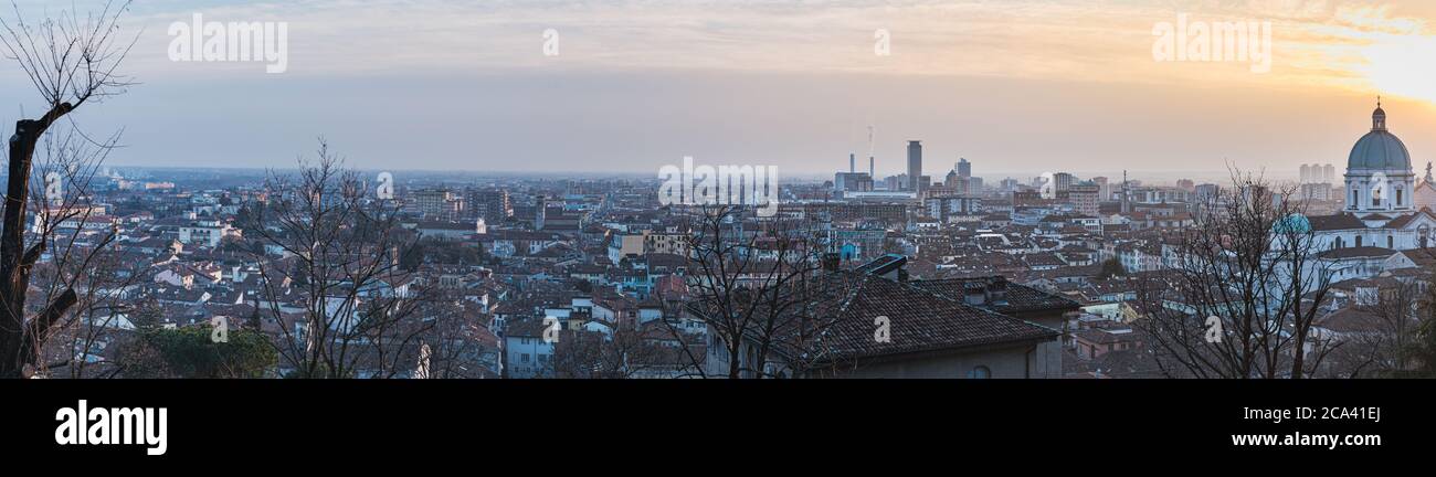 Brescia 's skyline at sunset: the large city highlights human overpopulation issue, housing space problems, economical development and society growth Stock Photo