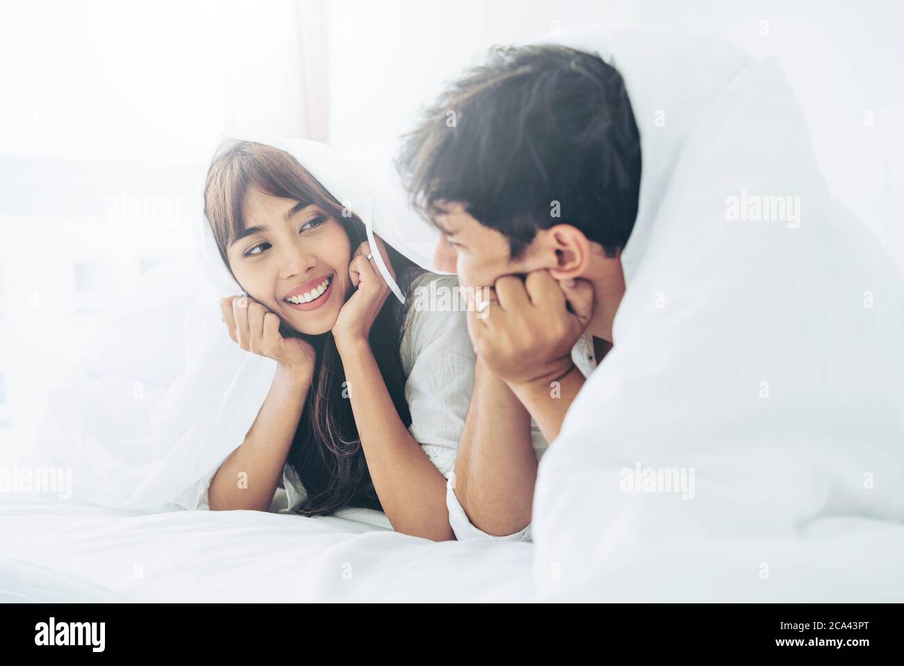 Happy young couple relaxing in the home bedroom. Stock Photo