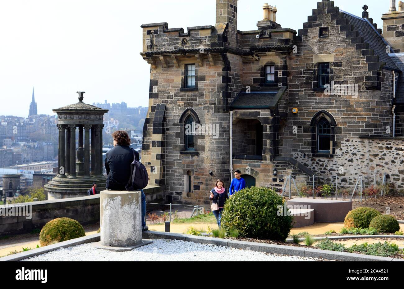Visitors in front of Old Observatory House and the Dugald Stewart Monument on Calton Hill in Edinburgh, Scotland Stock Photo