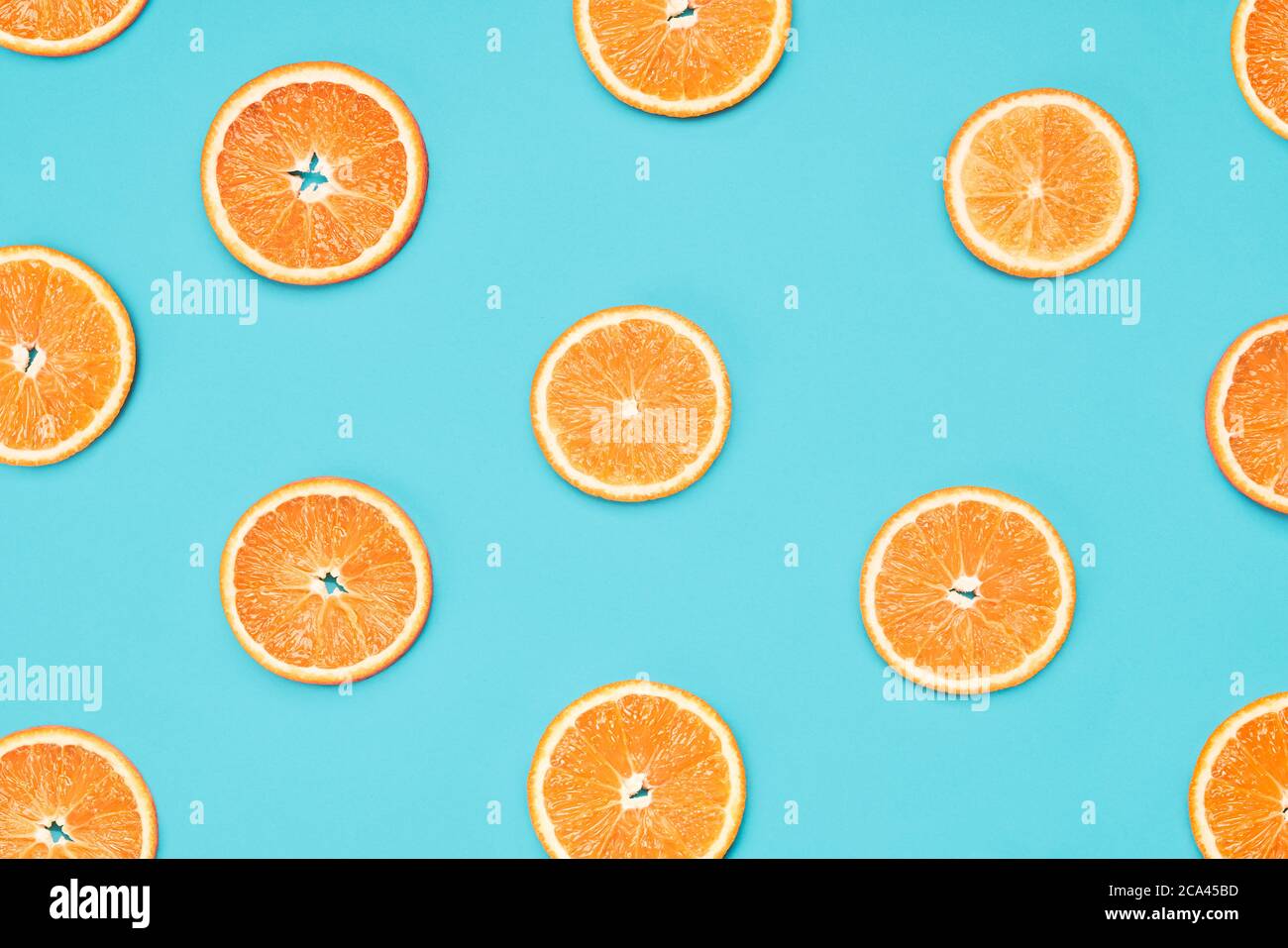 Orange slices on blue background. Food wallpaper, summer concept Stock Photo