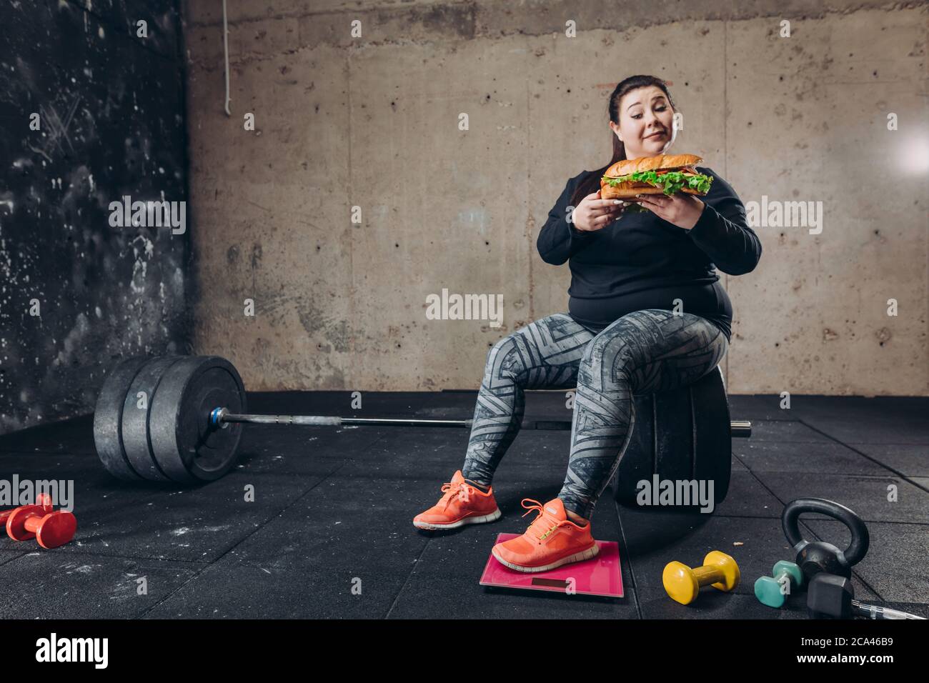 disadvantages of eating fast food. full length photo. hungry sportswoman. girl destroys her diet.enjoyment Stock Photo