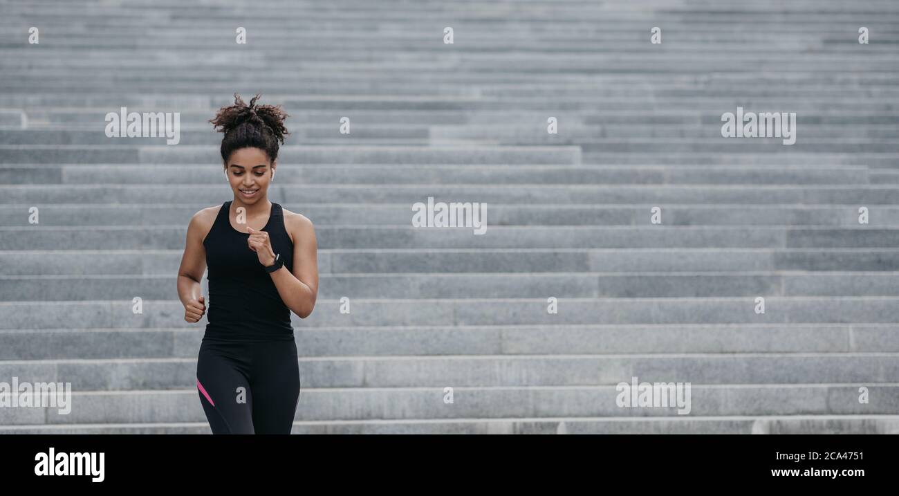 Strong athletic woman is running. Happy girl in sportswear with fitness  tracker doing cardio workout on stairs Stock Photo - Alamy