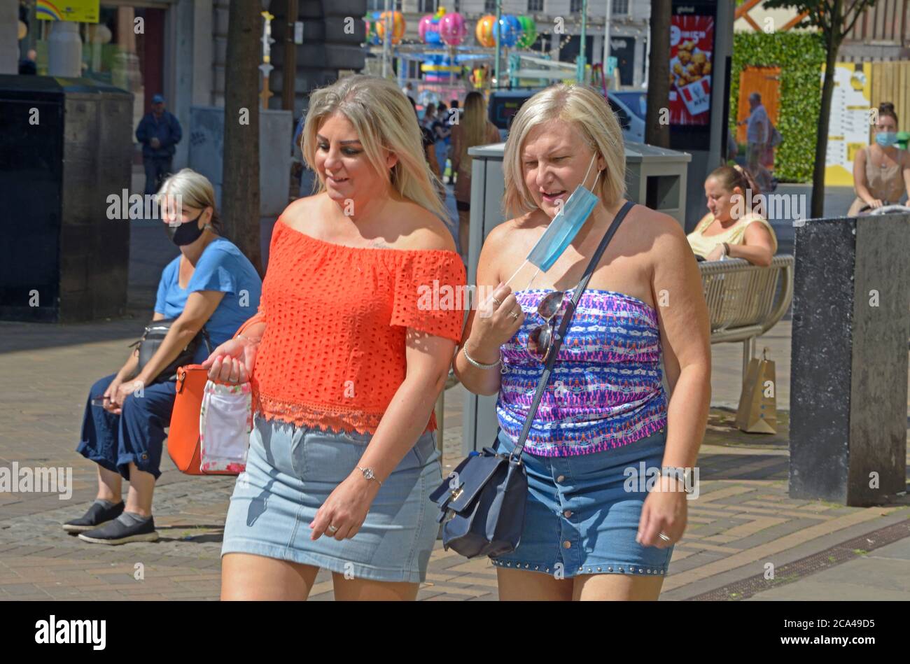 Chubby women out shopping, post lockdown, one with mask. Stock Photo