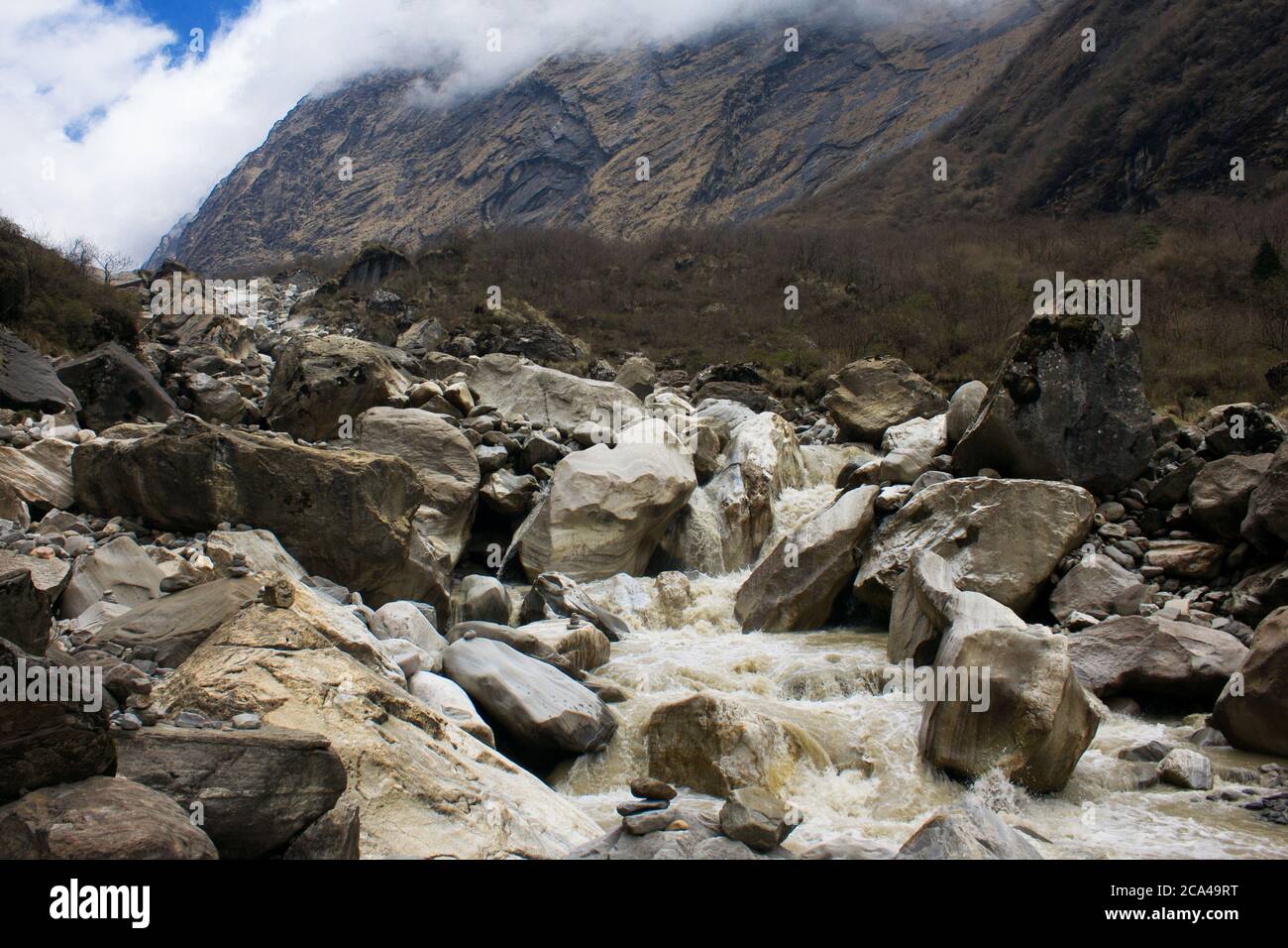 Mountain river and waterfall flowing through the rocks in Annapurna Massif valley on the Nepal ABC trek Stock Photo