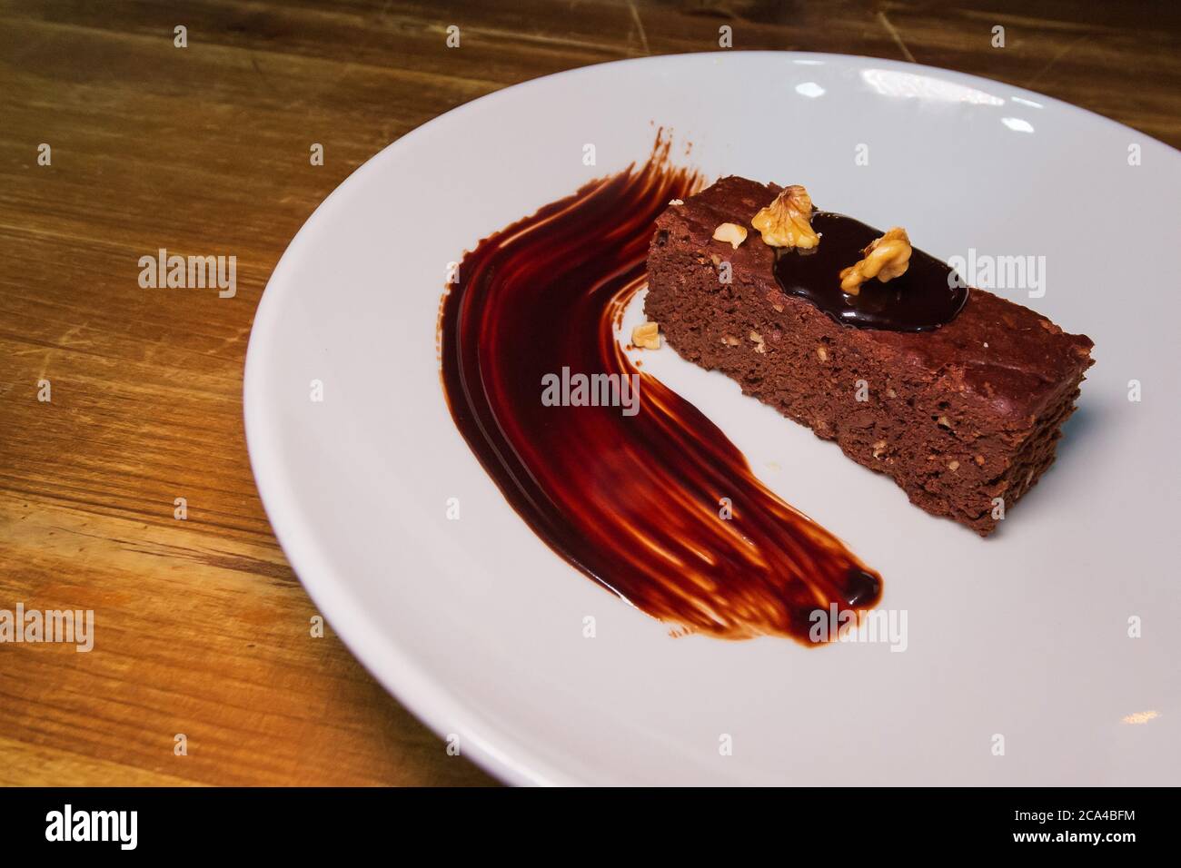 Brownie with chocolate syrup and hazelnuts. Stock Photo