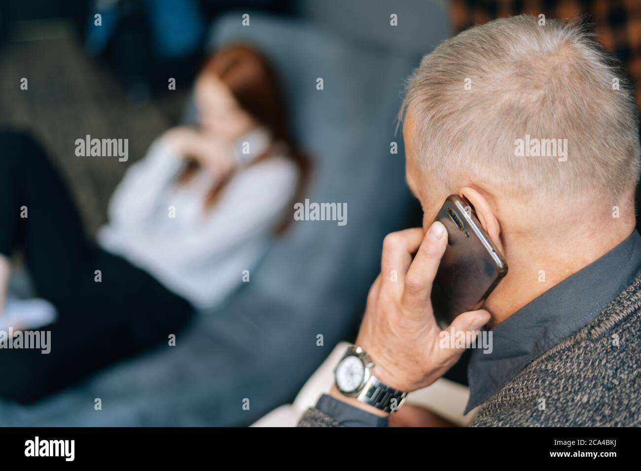 Close-up view of unrecognizable mature man talking on cell phone with friend client colleague. Stock Photo