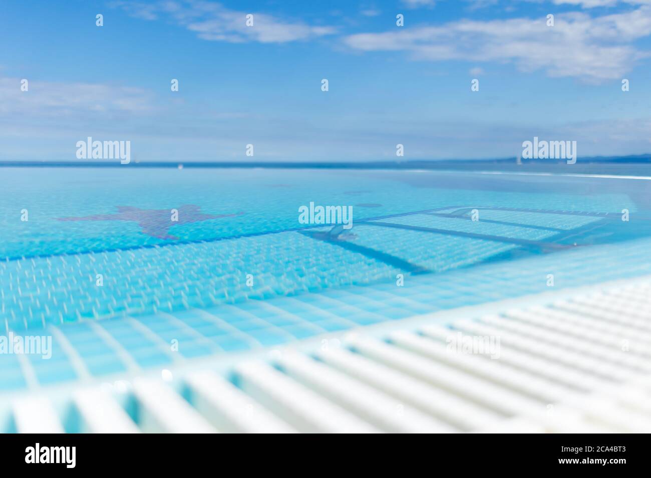 Swimming pool and blue water at the resort with beautiful sea view. Stock Photo