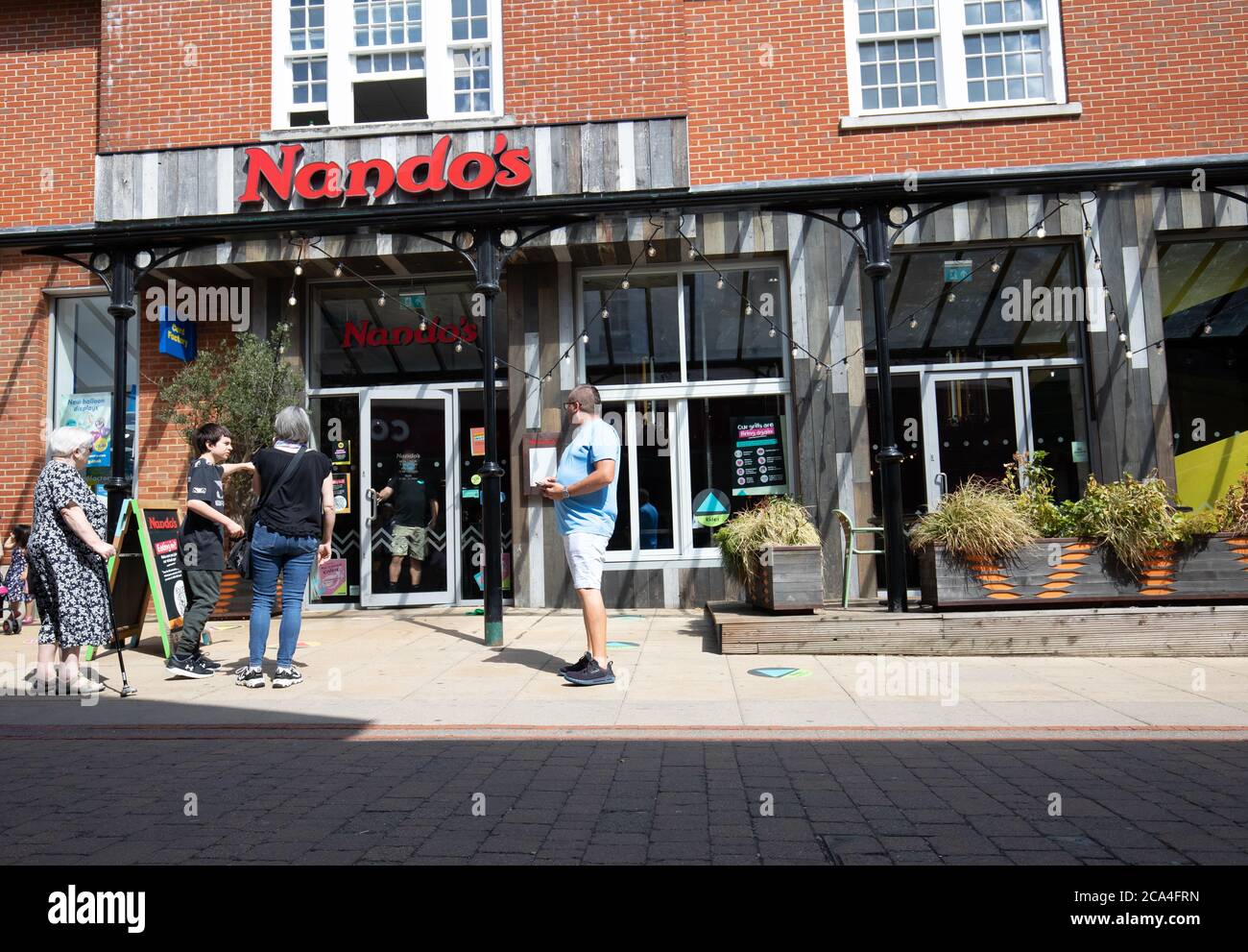 Sevenoaks, Kent,4th August 2020, People passing Nando's restaurant in Sevenoaks, Kent. The forecast is for 20C sunny with a gentle breeze and is to get hotter as the week continues with temperatures expected of 32C or more on Friday. Credit: Keith Larby/Alamy Live News Stock Photo