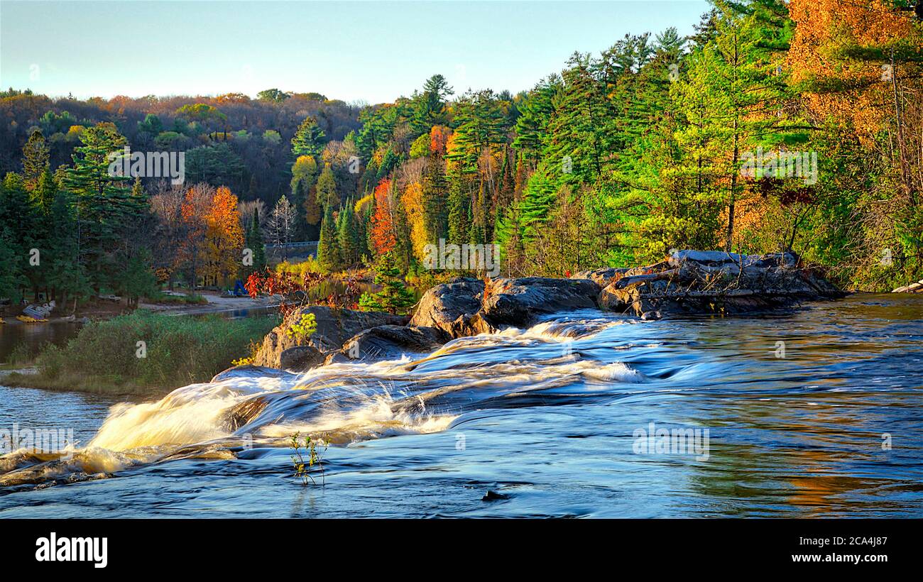 Waterfall Rocks Side View Sunset landscape scene of the waterfall on dark-colored rocks - side ...